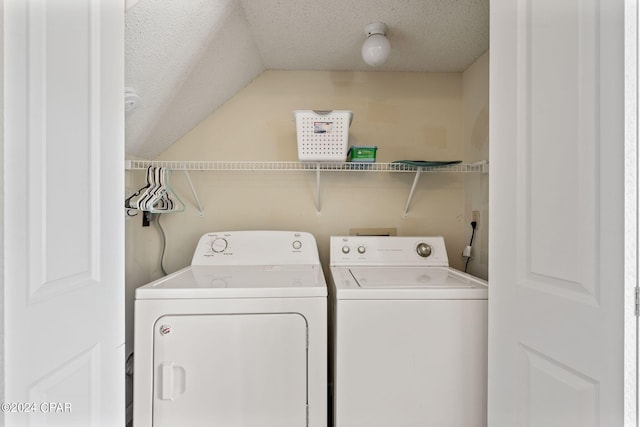 washroom with a textured ceiling and washing machine and clothes dryer