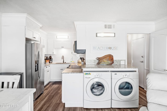 washroom featuring sink, independent washer and dryer, a textured ceiling, ornamental molding, and dark hardwood / wood-style flooring