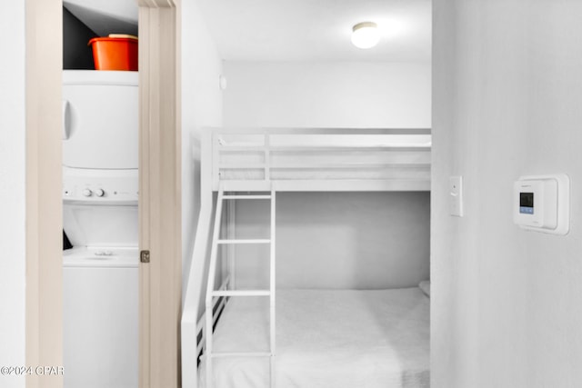 clothes washing area with stacked washer and dryer