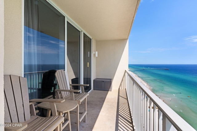 balcony featuring a water view and a beach view