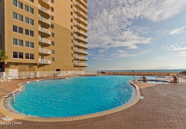 view of swimming pool with a water view and a patio area