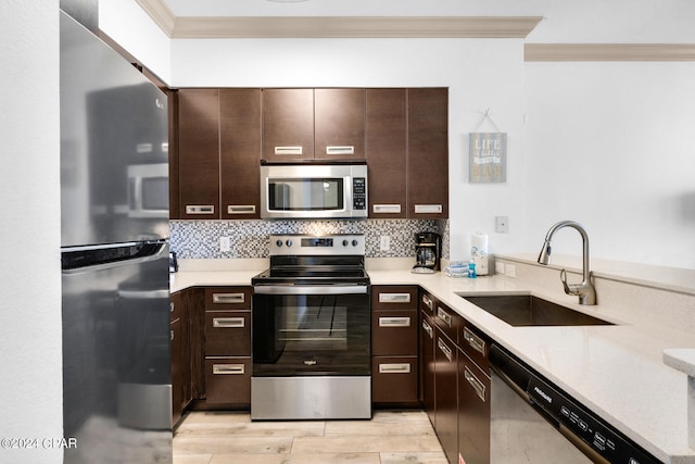 kitchen with crown molding, sink, dark brown cabinets, and appliances with stainless steel finishes