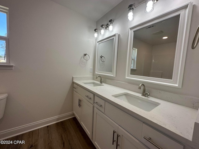 bathroom with toilet, vanity, and hardwood / wood-style flooring