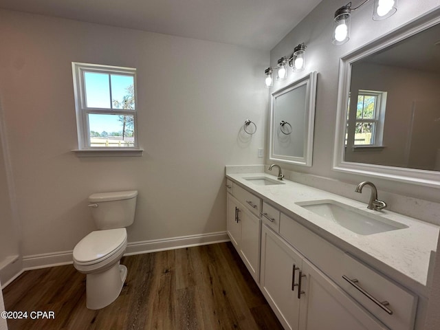 bathroom with wood-type flooring, vanity, toilet, and plenty of natural light