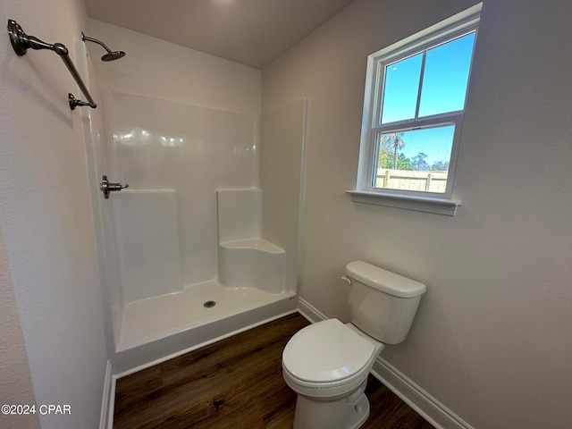 bathroom featuring hardwood / wood-style flooring, toilet, and walk in shower