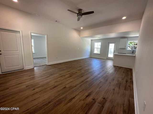 unfurnished living room featuring dark hardwood / wood-style floors and ceiling fan