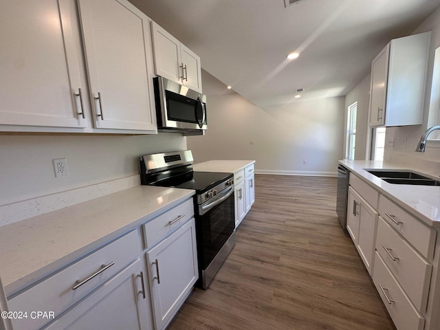 kitchen with white cabinetry, sink, stainless steel appliances, and dark hardwood / wood-style floors