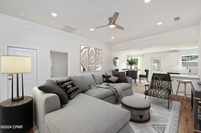 living room with hardwood / wood-style flooring, ceiling fan, and sink