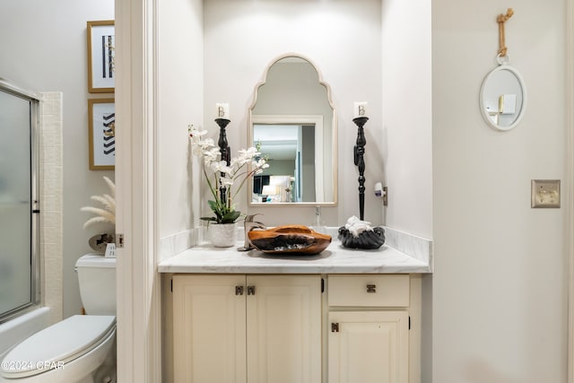 full bathroom with vanity, toilet, and enclosed tub / shower combo