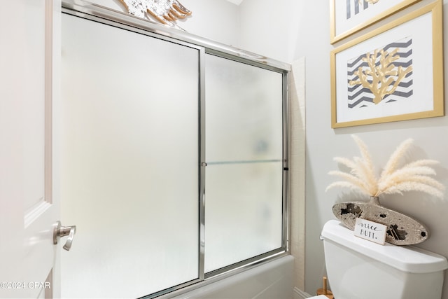 bathroom with shower / bath combination with glass door and toilet