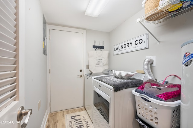 laundry area featuring washing machine and dryer, light wood-type flooring, and radiator heating unit