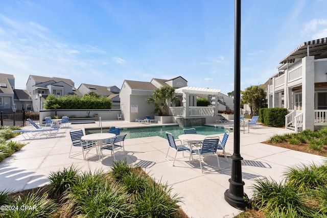 view of pool with a pergola, pool water feature, and a patio