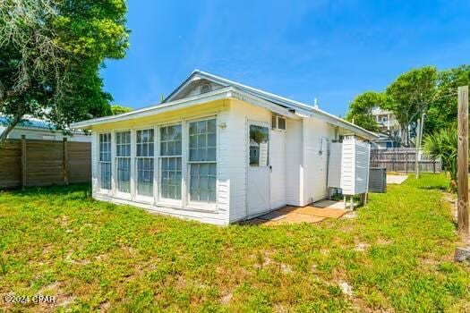 back of house featuring a lawn and central air condition unit