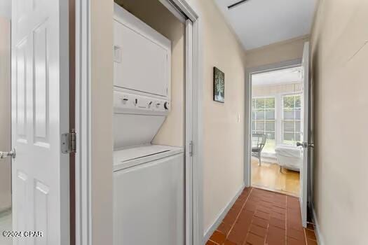 208 3rd St Unit 1/2, Panama City Beach, FL 32413 - washroom with stacked washer and clothes dryer and baseboards