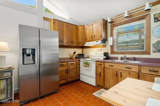 208 3rd St Unit 1/2, Panama City Beach, FL 32413 - kitchen featuring stainless steel refrigerator with ice dispenser, white range with electric cooktop, exhaust hood, a sink, and vaulted ceiling