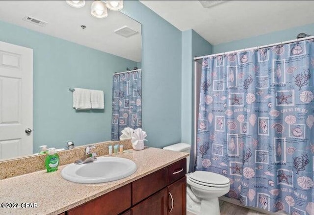 bathroom with toilet, curtained shower, visible vents, and vanity