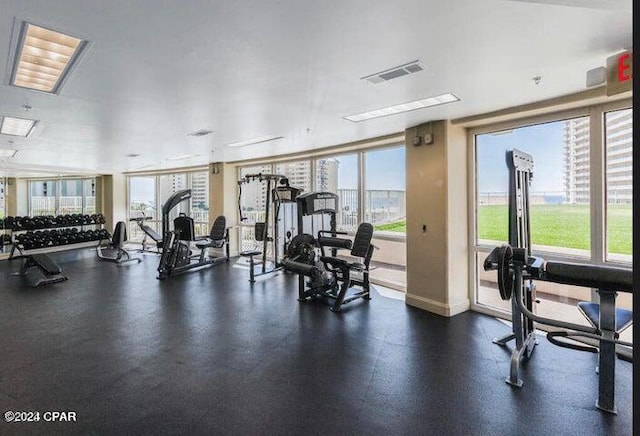 gym featuring a wealth of natural light, visible vents, and a city view