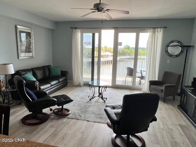 living room with light wood finished floors and a ceiling fan