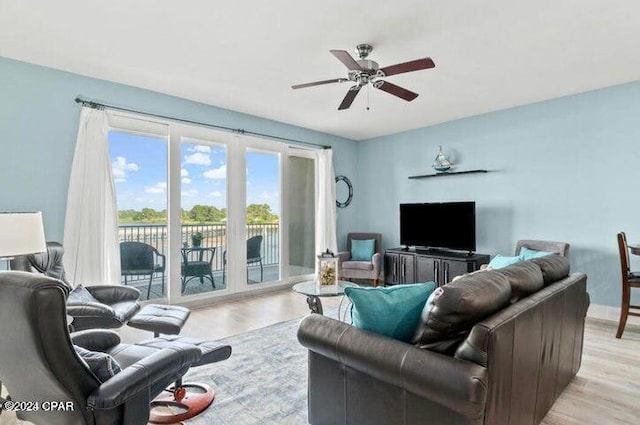 living room with a ceiling fan and light wood-style flooring