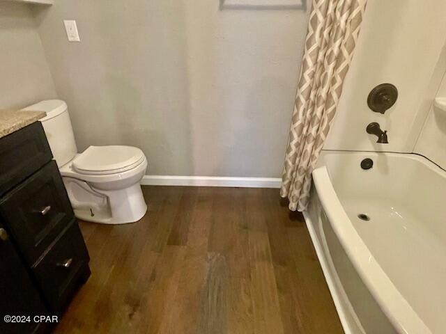 full bathroom featuring wood-type flooring, vanity, toilet, and shower / bath combo with shower curtain