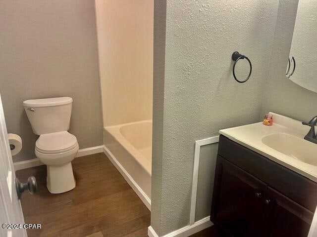 bathroom with hardwood / wood-style floors, vanity, and toilet