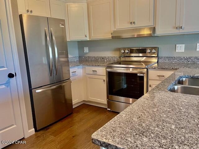 kitchen featuring sink, dark hardwood / wood-style floors, light stone countertops, white cabinetry, and stainless steel appliances