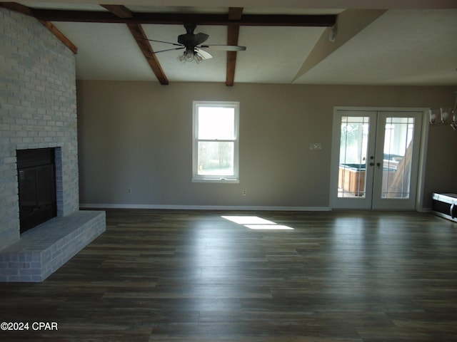 unfurnished living room featuring french doors, a brick fireplace, ceiling fan, vaulted ceiling with beams, and a healthy amount of sunlight