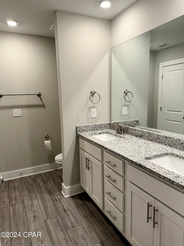 bathroom with vanity, toilet, and wood-type flooring