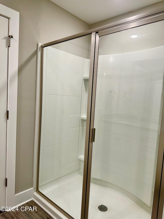 bathroom featuring an enclosed shower and hardwood / wood-style flooring