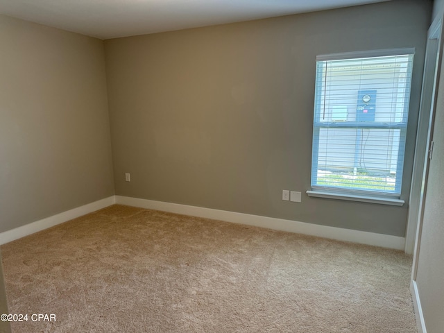 unfurnished room featuring light carpet