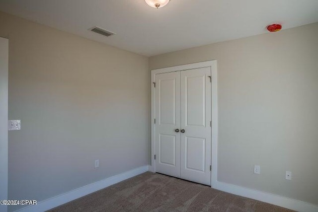 unfurnished bedroom with carpet flooring and a closet