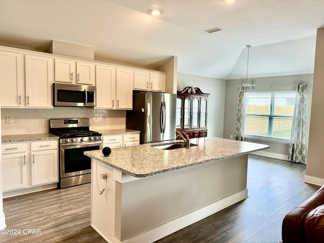 kitchen featuring sink, lofted ceiling, a kitchen island with sink, white cabinets, and appliances with stainless steel finishes