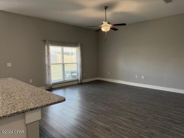 unfurnished living room with dark hardwood / wood-style floors and ceiling fan