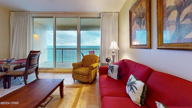 tiled living room featuring a wealth of natural light and a water view