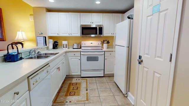 kitchen featuring light tile flooring, sink, white cabinets, and white appliances