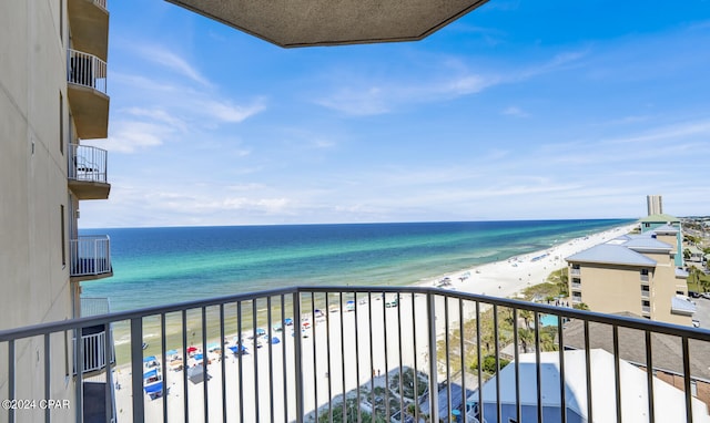 balcony with a water view and a view of the beach