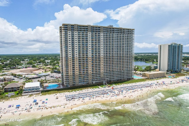 birds eye view of property with a water view and a beach view