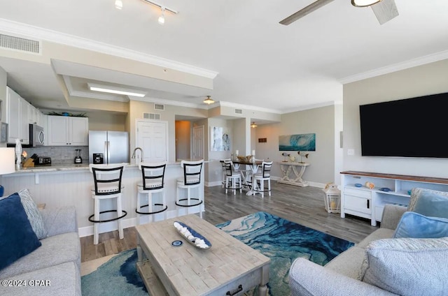 living room featuring ceiling fan, crown molding, dark hardwood / wood-style flooring, and rail lighting