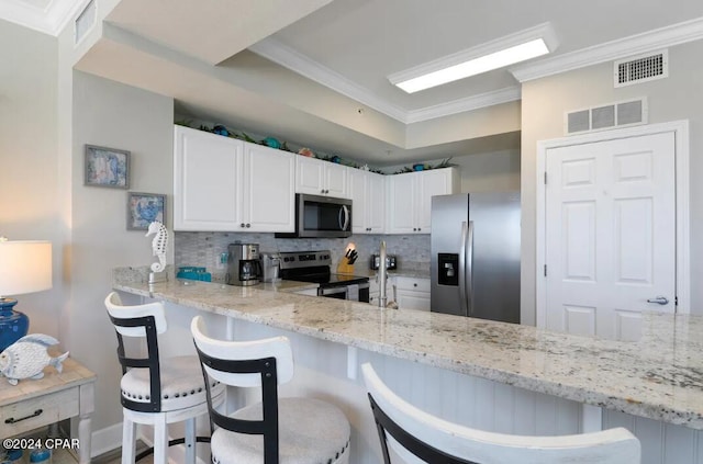 kitchen featuring appliances with stainless steel finishes, tasteful backsplash, white cabinets, and light stone countertops