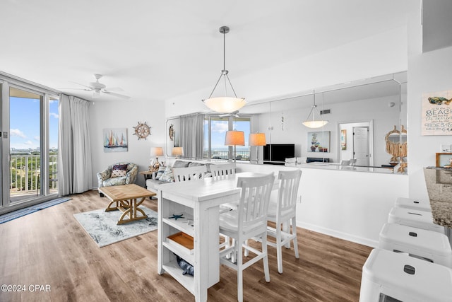 dining space with hardwood / wood-style floors and ceiling fan