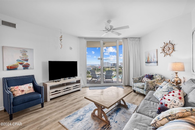 living room featuring expansive windows, ceiling fan, and hardwood / wood-style flooring