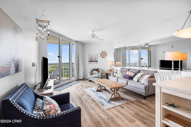 living room with french doors, ceiling fan, and light wood-type flooring