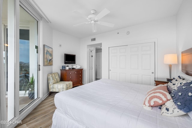 bedroom with a closet, hardwood / wood-style floors, ceiling fan, and access to exterior