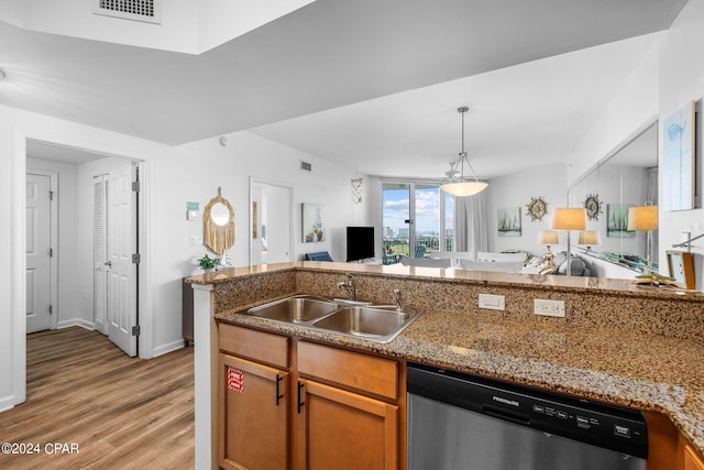 kitchen with light hardwood / wood-style flooring, stone countertops, stainless steel dishwasher, sink, and pendant lighting