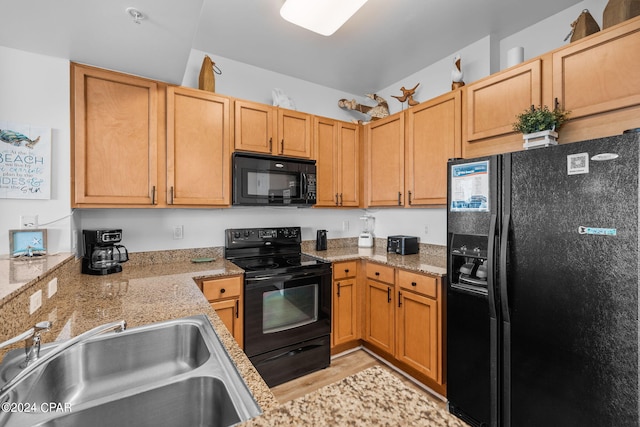 kitchen with sink, black appliances, and light wood-type flooring