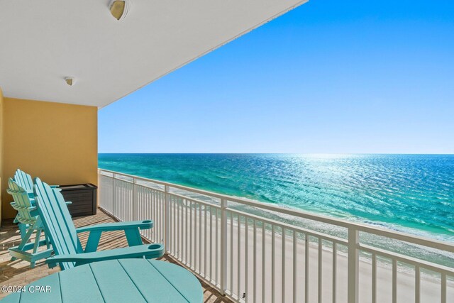 balcony featuring a view of the beach and a water view