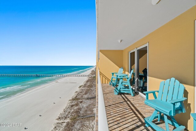 balcony featuring a beach view and a water view