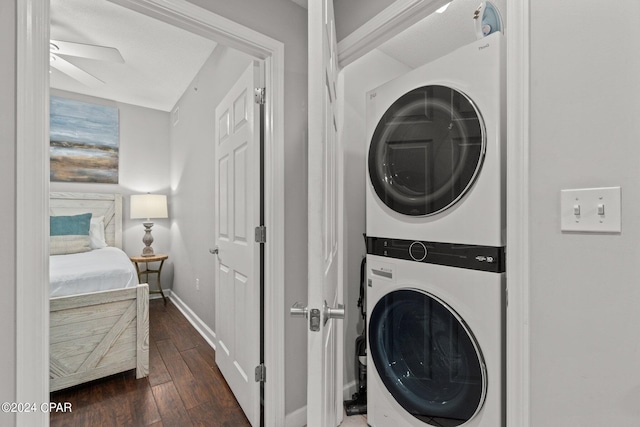 laundry area with ceiling fan, stacked washer and dryer, and dark hardwood / wood-style flooring