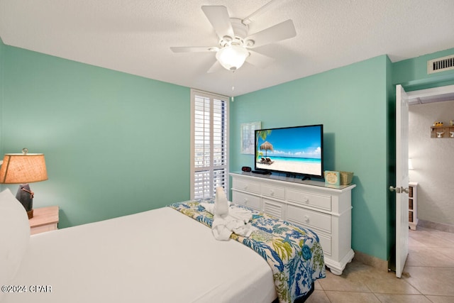 bedroom with light tile patterned flooring, a textured ceiling, and ceiling fan