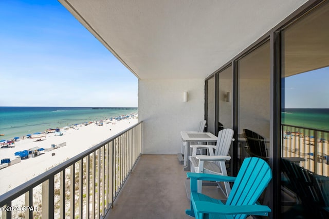 balcony featuring a water view and a beach view